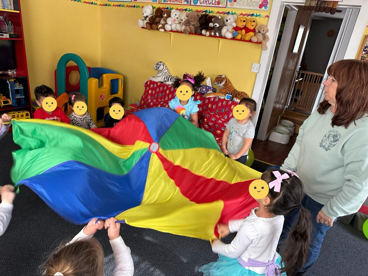 Children playing with a colorful parachute.